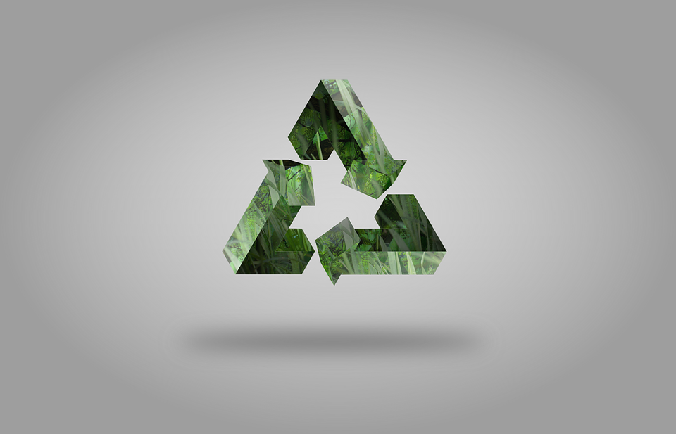 Recycling symbol in green on grey background