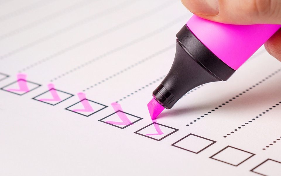 Pen ticking checklist on white paper